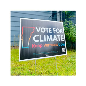 Yard sign with 'Vote for Climate, Keep Vermont Cool' text on a grassy background.