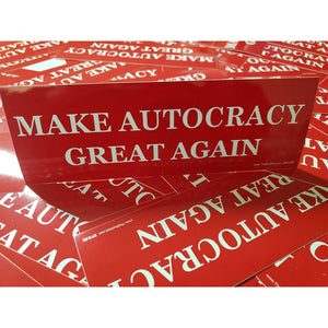 Red stickers with 'MAKE AUTOCRACY GREAT AGAIN' text on a white background