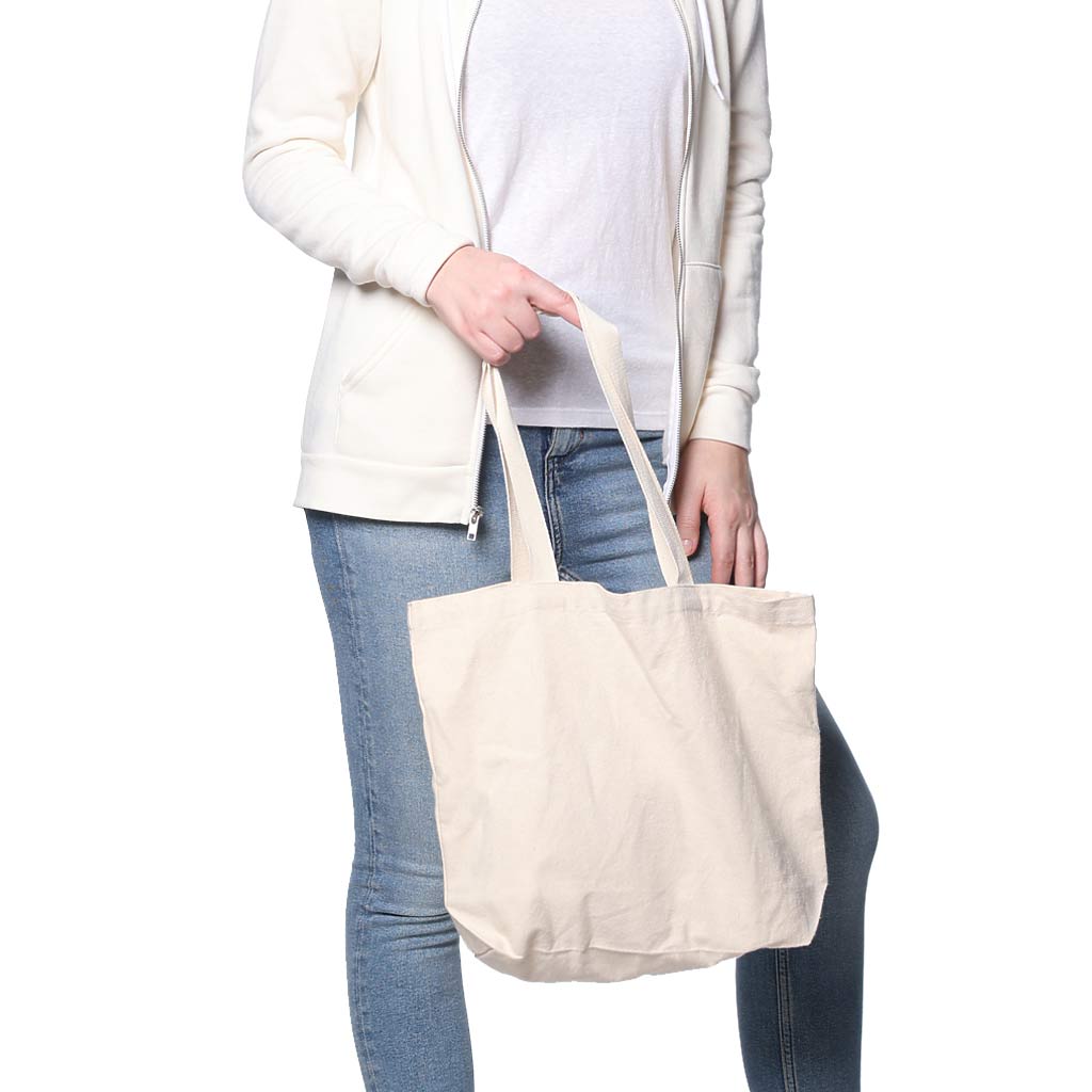 Woman holding a small cotton canvas tote bag